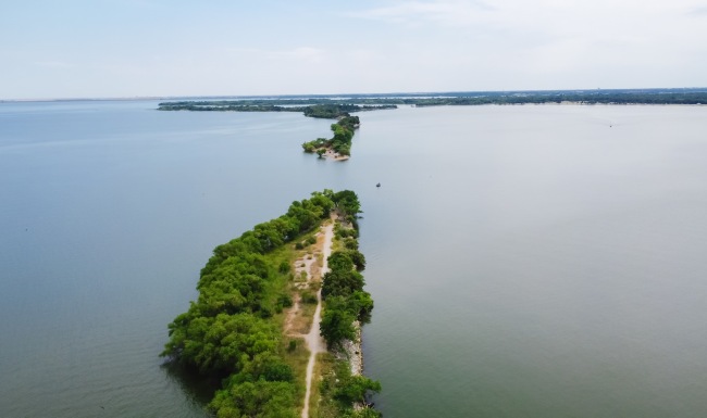 an aerial view of a body of water with a road